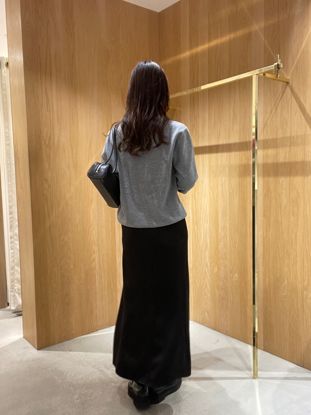 グレー系のニット/セーター、ブラック系のスカート、ブラック系のローファーを着用したレディースの秋コーディネートの6枚目の写真