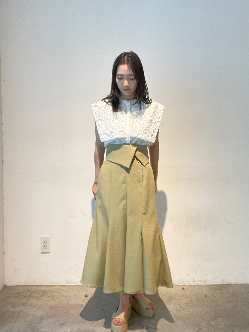 ホワイト系のシャツ/ブラウス、ベージュ系のサンダル、イエロー系のスカートを着用したレディースの夏コーディネートの2枚目の写真