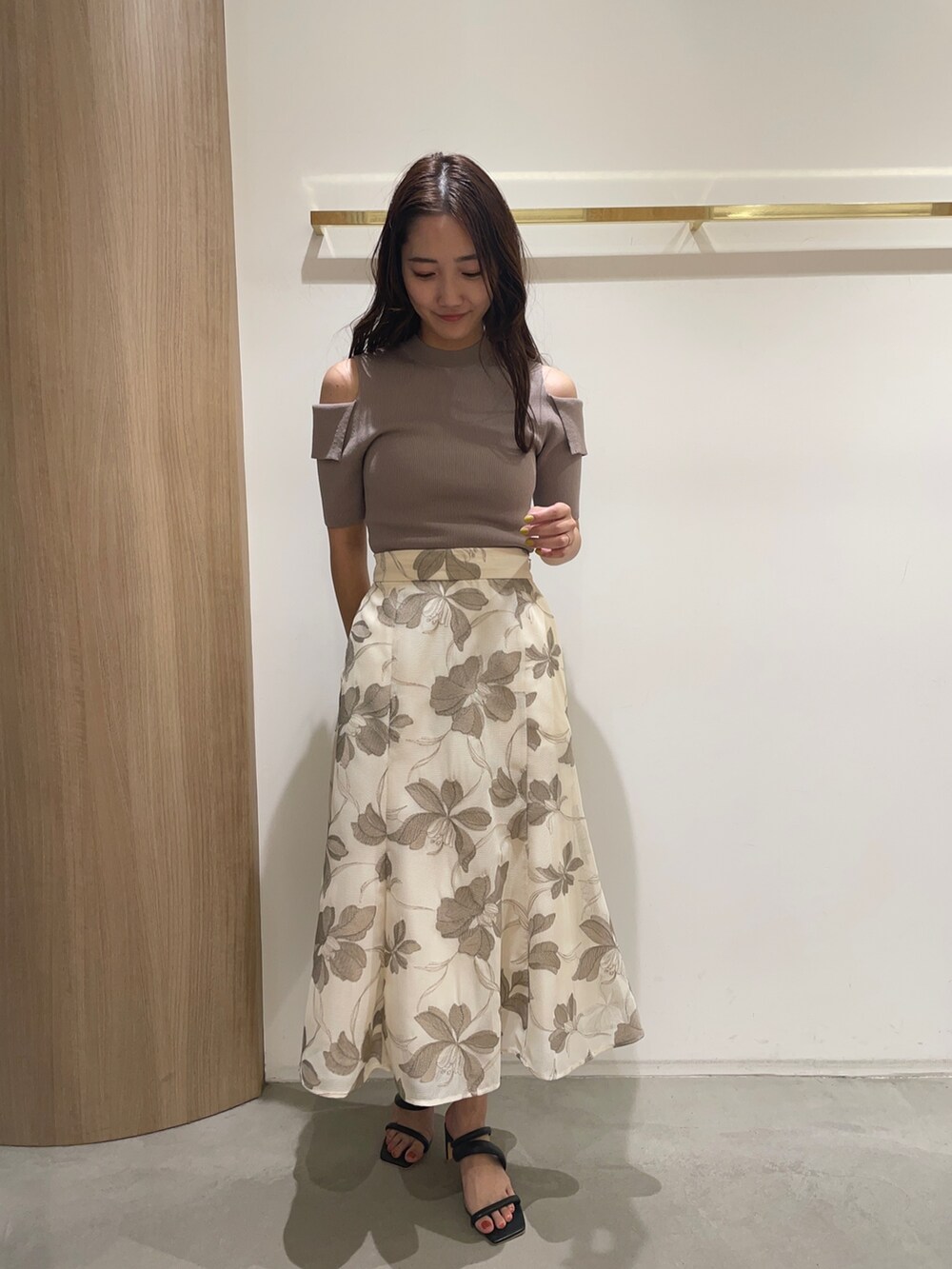 ベージュ系のスカート、ベージュ系のニット/セーター、ブラック系のサンダルを着用したレディースの春コーディネートの3枚目の写真