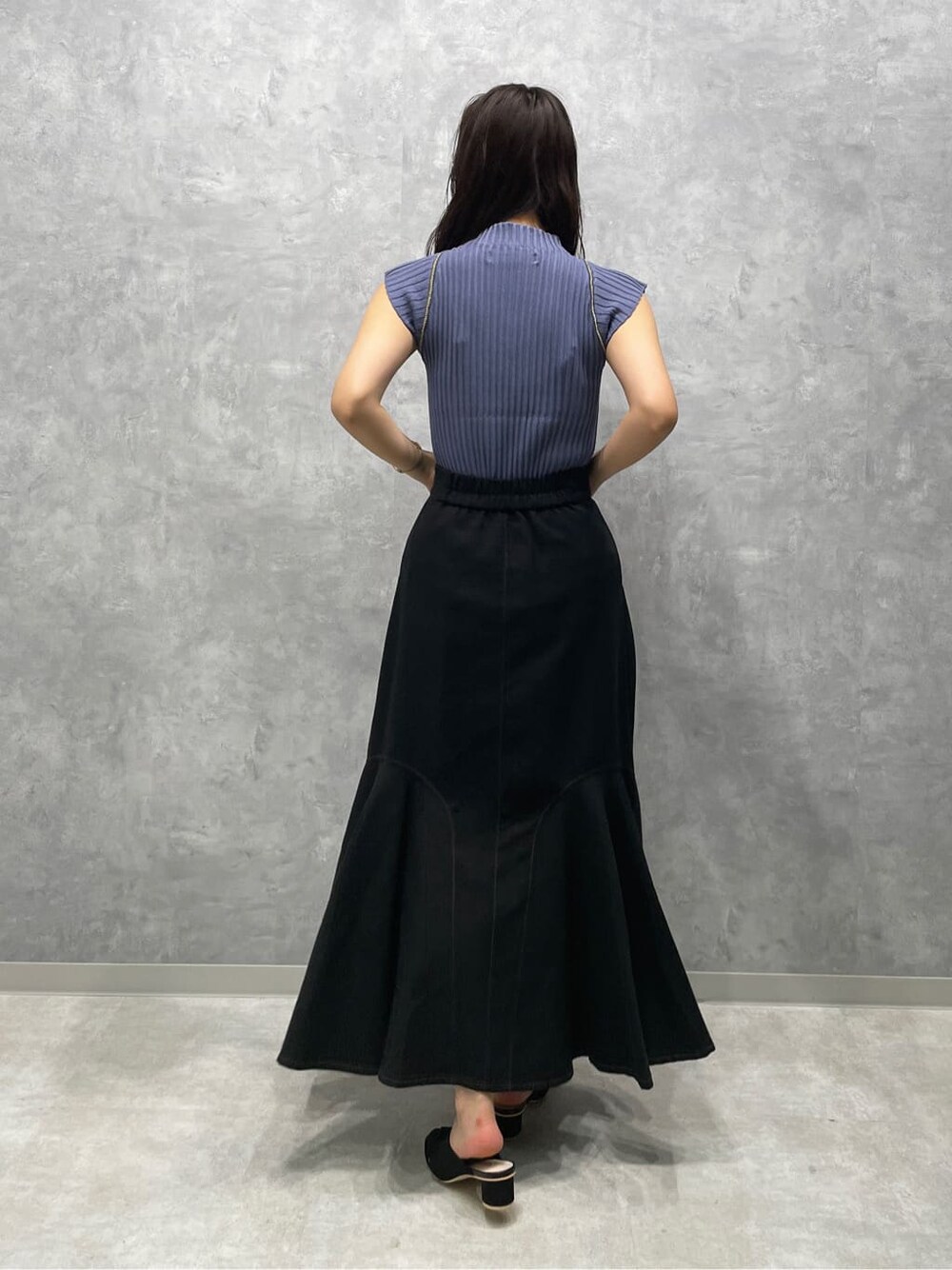 ブラック系のサンダル、ブラック系のスカート、ブルー系のニット/セーターを着用したレディースの夏コーディネートの4枚目の写真