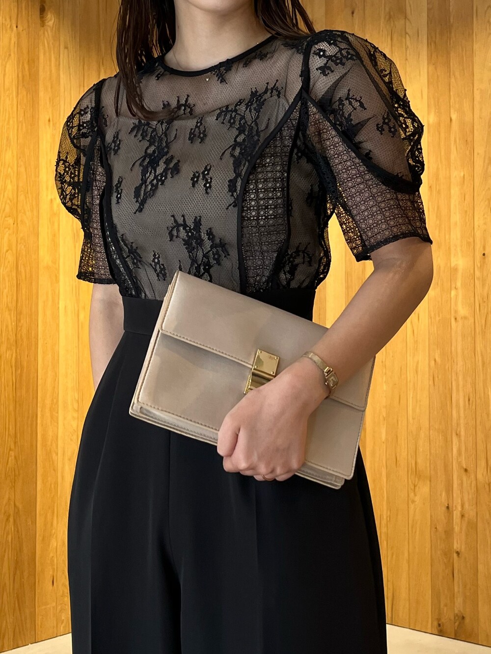 ベージュ系のパンプス、ベージュ系のクラッチバッグ、ブラック系のパンツドレスを着用したレディースの冬コーディネートの6枚目の写真