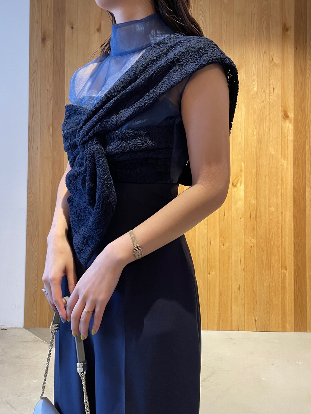 グレー系のクラッチバッグ、グレー系のパンプス、ブルー系のパンツドレスを着用したレディースの冬コーディネートの6枚目の写真