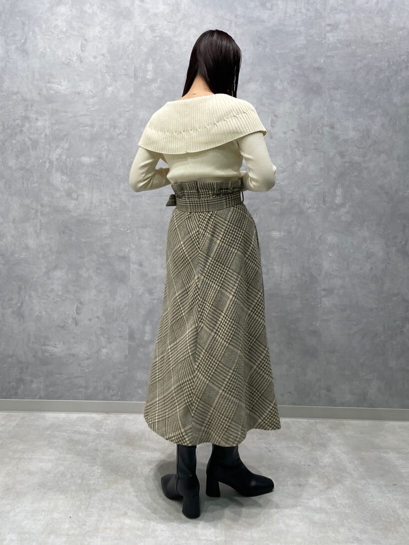 ブラック系のブーツ、ベージュ系のスカート、ホワイト系のニット/セーターを着用したレディースの秋コーディネートの5枚目の写真