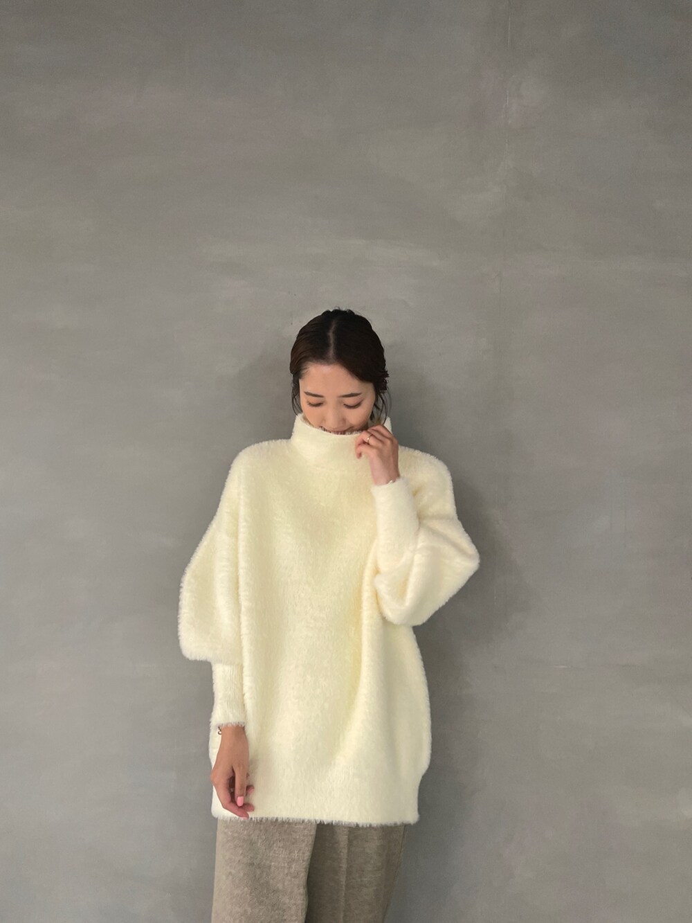 ホワイト系のニット/セーター、ベージュ系のその他パンツ、ホワイト系のブーツを着用したレディースの夏コーディネートの6枚目の写真