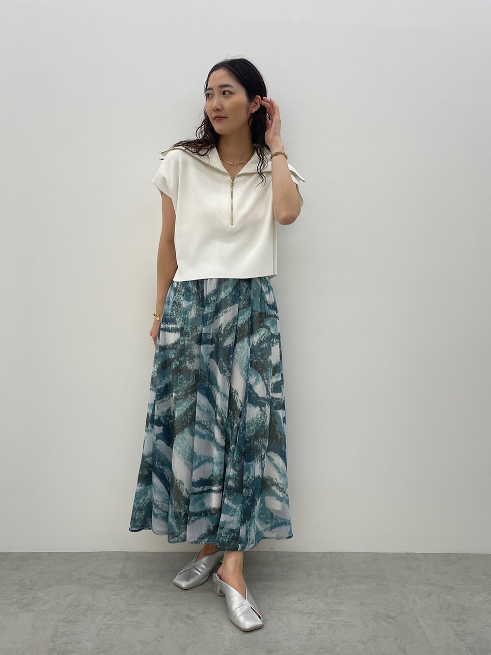 シルバー系のパンプス、ブルー系のスカート、ホワイト系のTシャツ/カットソーを着用したレディースの春コーディネートの5枚目の写真