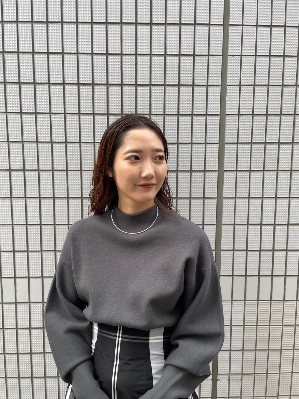 ブラック系のワンピース、ブラック系のブーツ、ブラック系のハンドバッグを着用したレディースの冬コーディネートの7枚目の写真