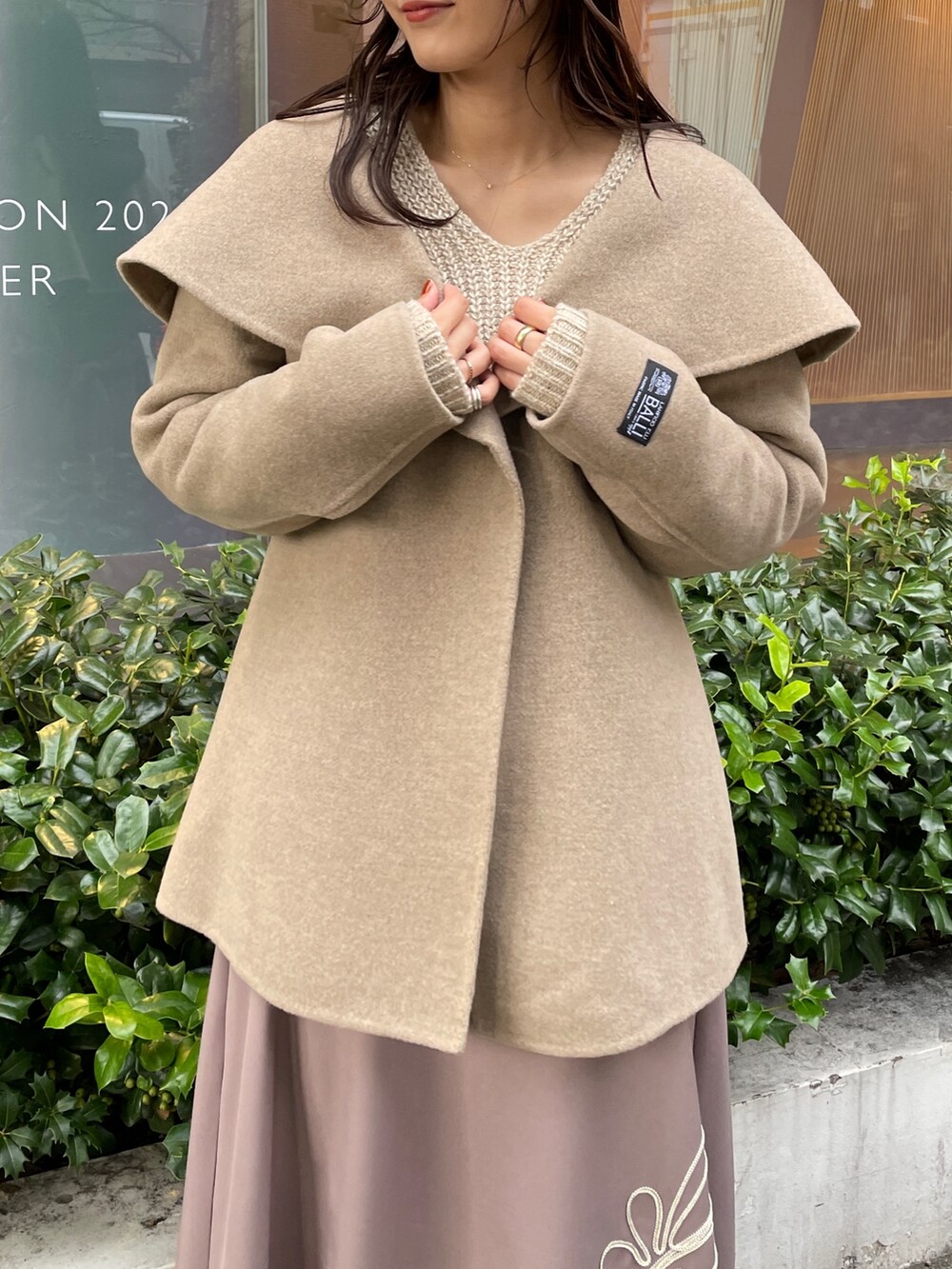 ホワイト系のニット/セーター、ホワイト系のその他アウター、ベージュ系のスカートを着用したレディースの秋コーディネートの10枚目の写真