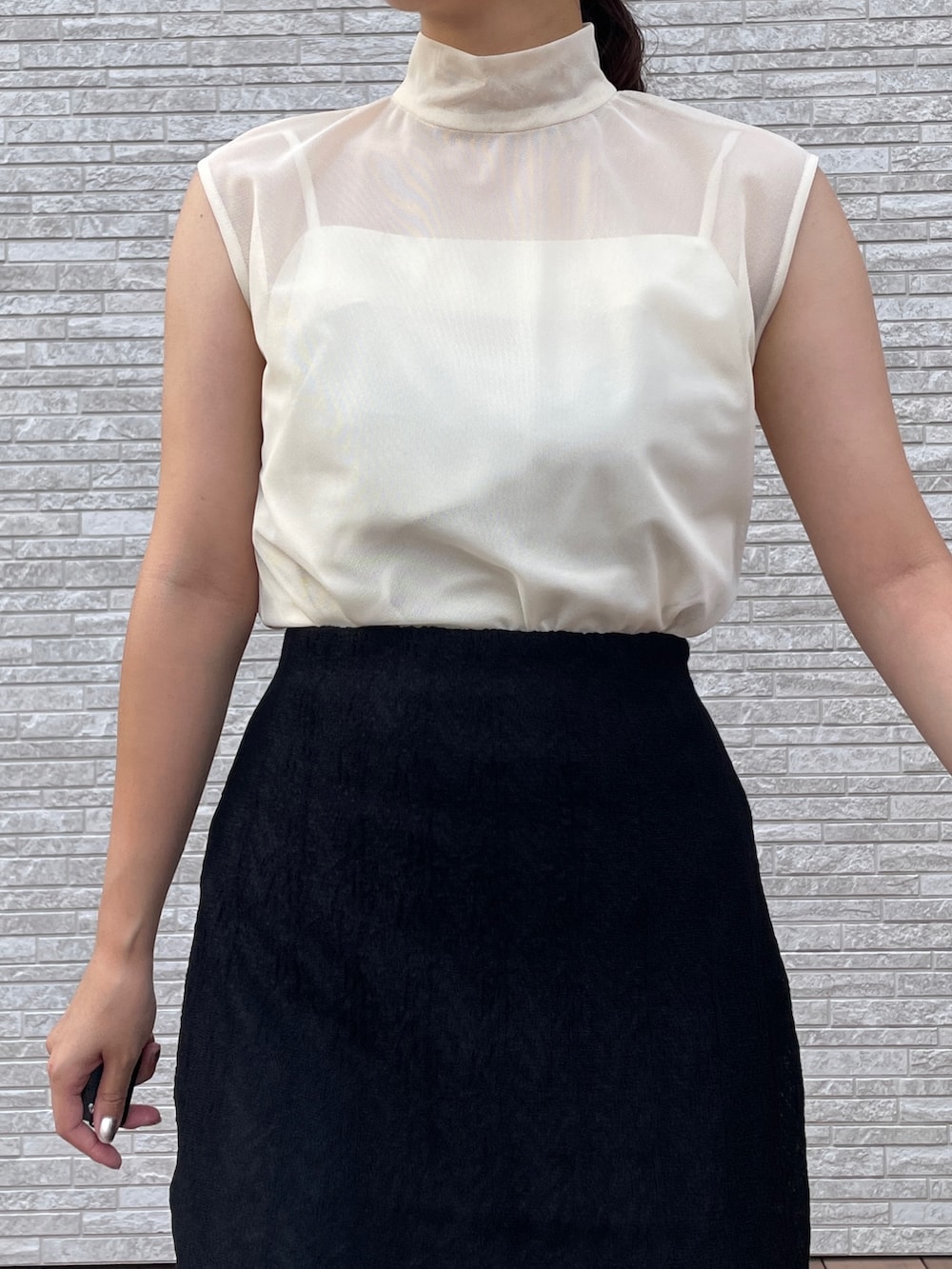 ブラック系のスカート、ホワイト系のTシャツ/カットソー、ブラック系のサンダルを着用したレディースの夏コーディネートの6枚目の写真