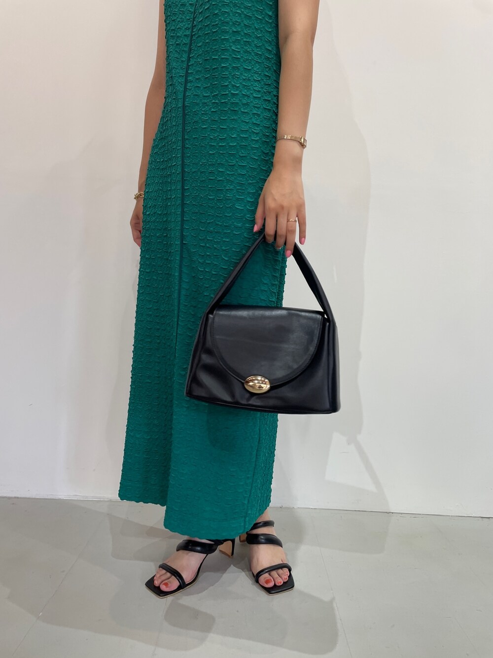 グリーン系のワンピース、ブラック系のサンダル、ブラック系のハンドバッグを着用したレディースの夏コーディネートの8枚目の写真