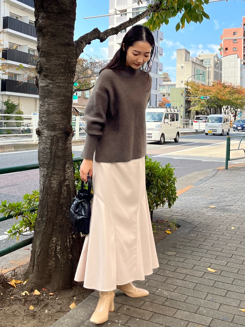 ベージュ系のニット/セーター、ベージュ系のブーツ、グレー系のスカートを着用したレディースの冬コーディネートの3枚目の写真