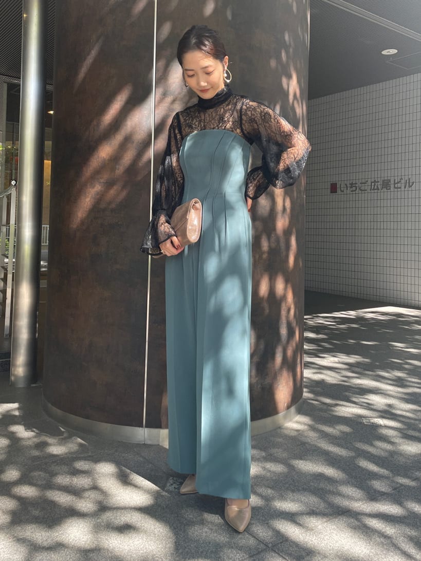 ゴールド系のクラッチバッグ、ゴールド系のパンプス、ブラック系のシャツ/ブラウスを着用したレディースの秋コーディネートの2枚目の写真