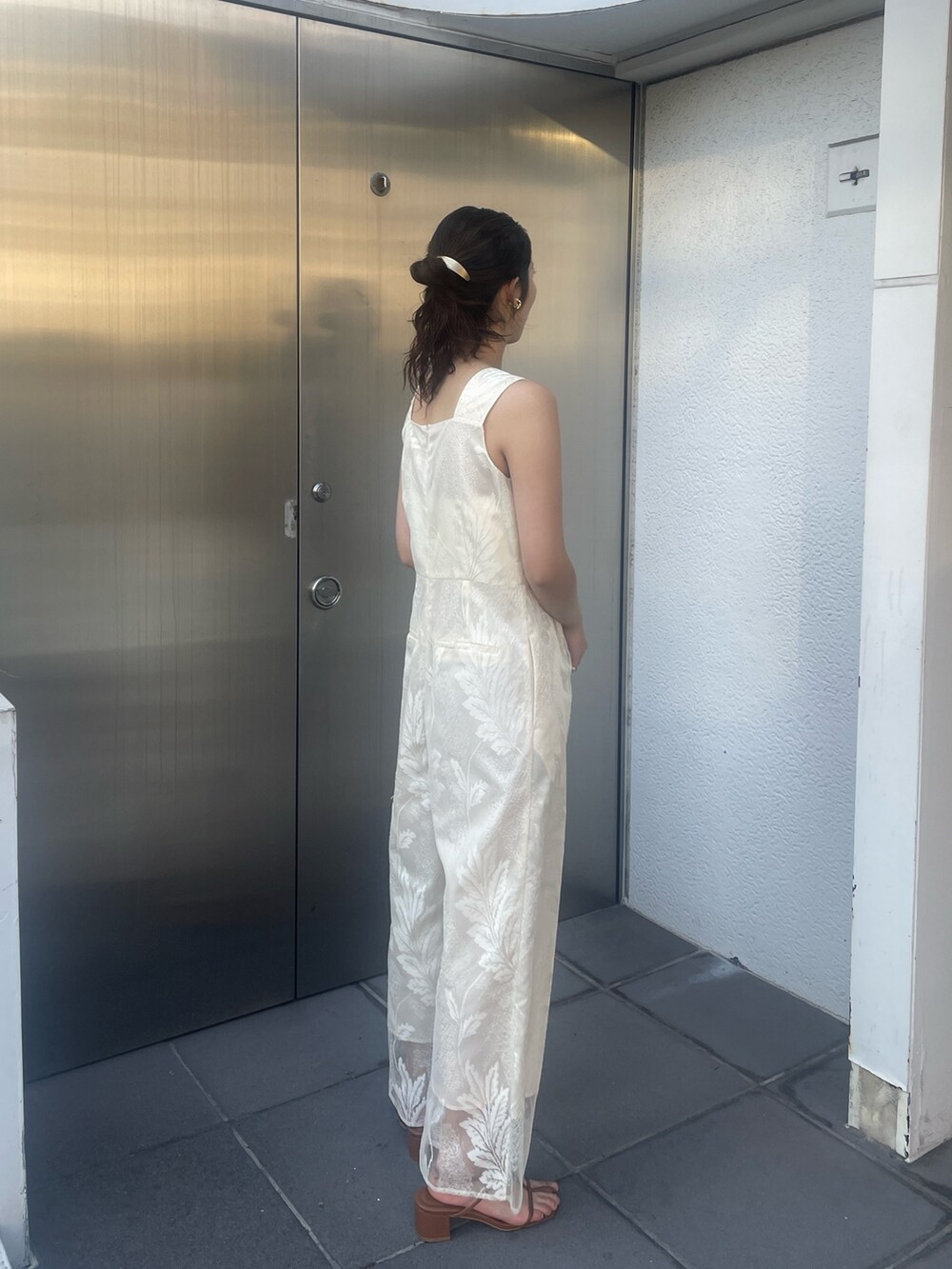 ブラウン系のサンダル、ホワイト系のつなぎ/オールインワン、ベージュ系の折りたたみ傘を着用したレディースの冬コーディネートの6枚目の写真