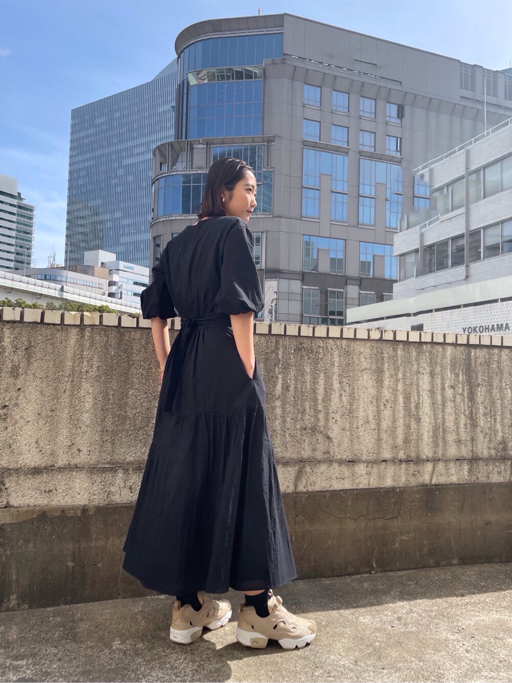 ブラック系のワンピースを着用したレディースの春コーディネートの3枚目の写真
