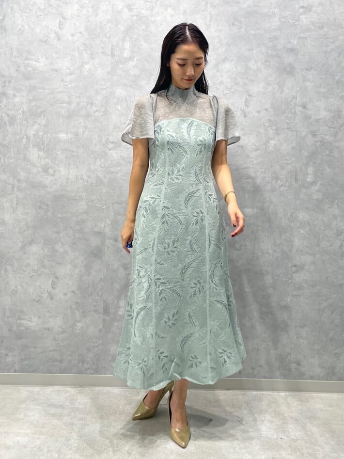 ゴールド系のパンプス、グリーン系のドレスを着用したレディースの秋コーディネートの4枚目の写真