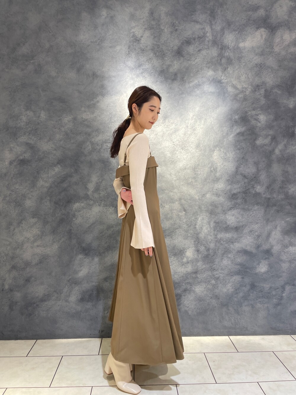ホワイト系のニット/セーター、ベージュ系のワンピース、ホワイト系のブーツを着用したレディースの冬コーディネートの8枚目の写真