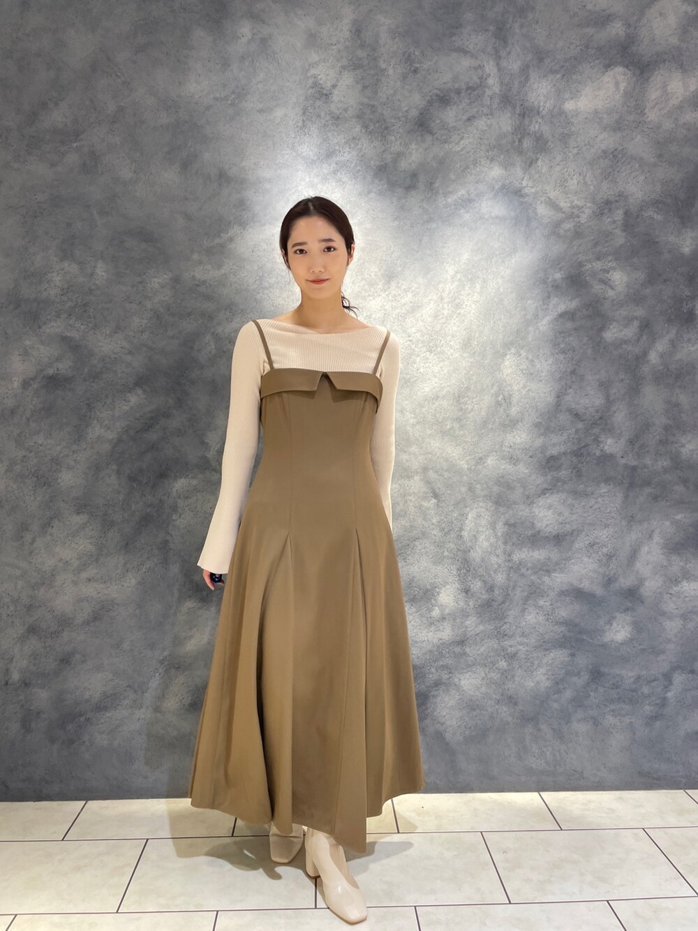 ホワイト系のニット/セーター、ベージュ系のワンピース、ホワイト系のブーツを着用したレディースの冬コーディネートの4枚目の写真