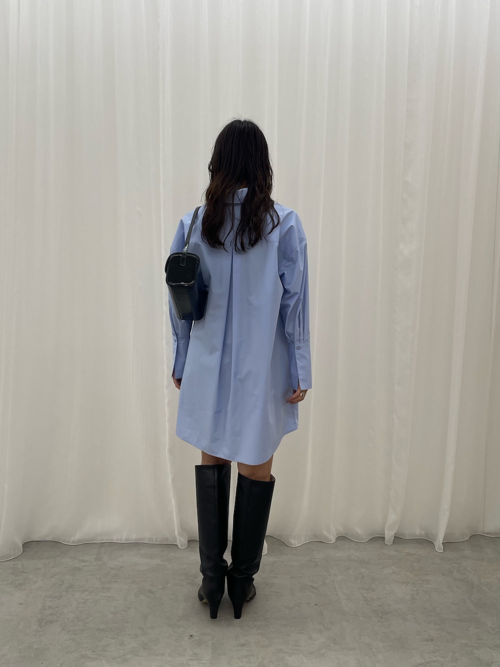 ブルー系のシャツワンピース、ブラック系のショルダーバッグを着用したレディースの秋コーディネートの6枚目の写真