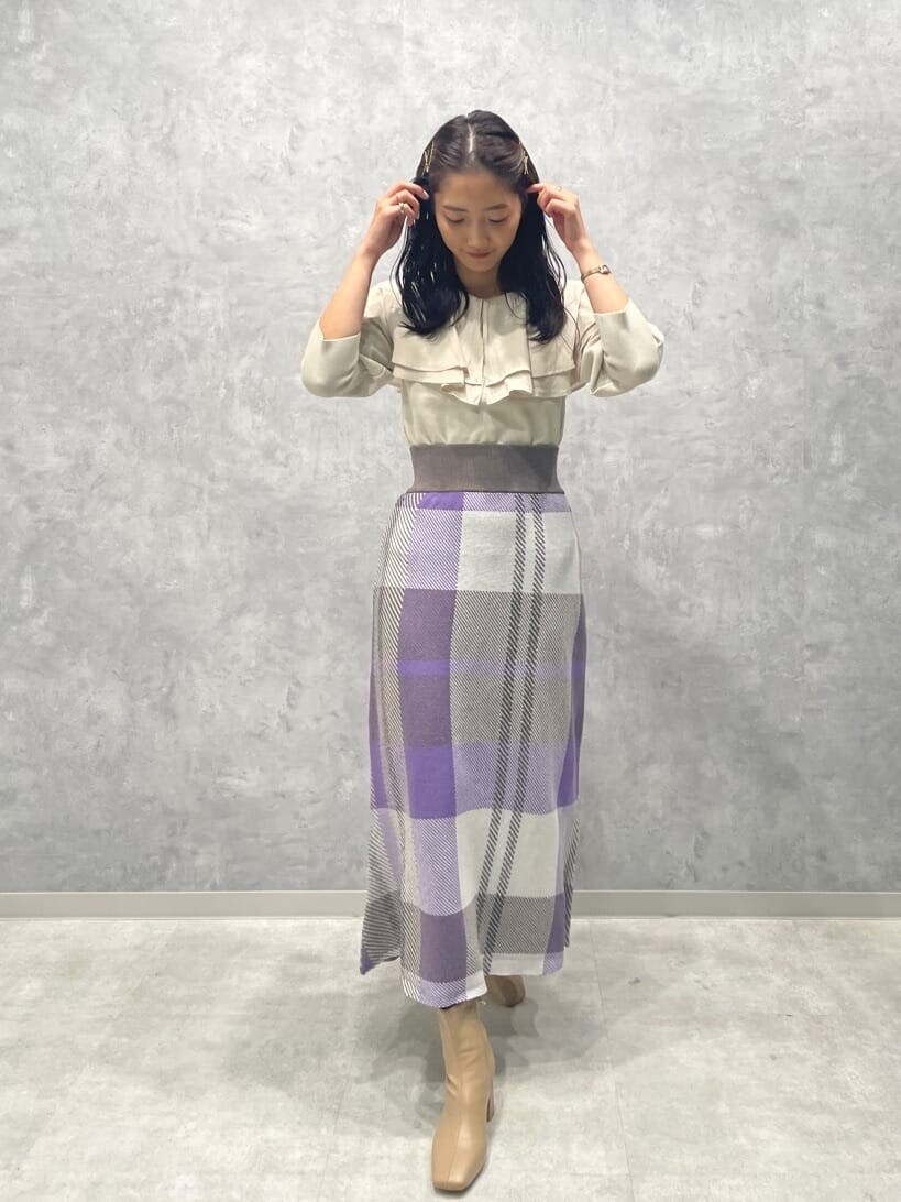 ベージュ系のブーツ、ホワイト系のニット/セーター、パープル系のスカートを着用したレディースの秋コーディネートの3枚目の写真