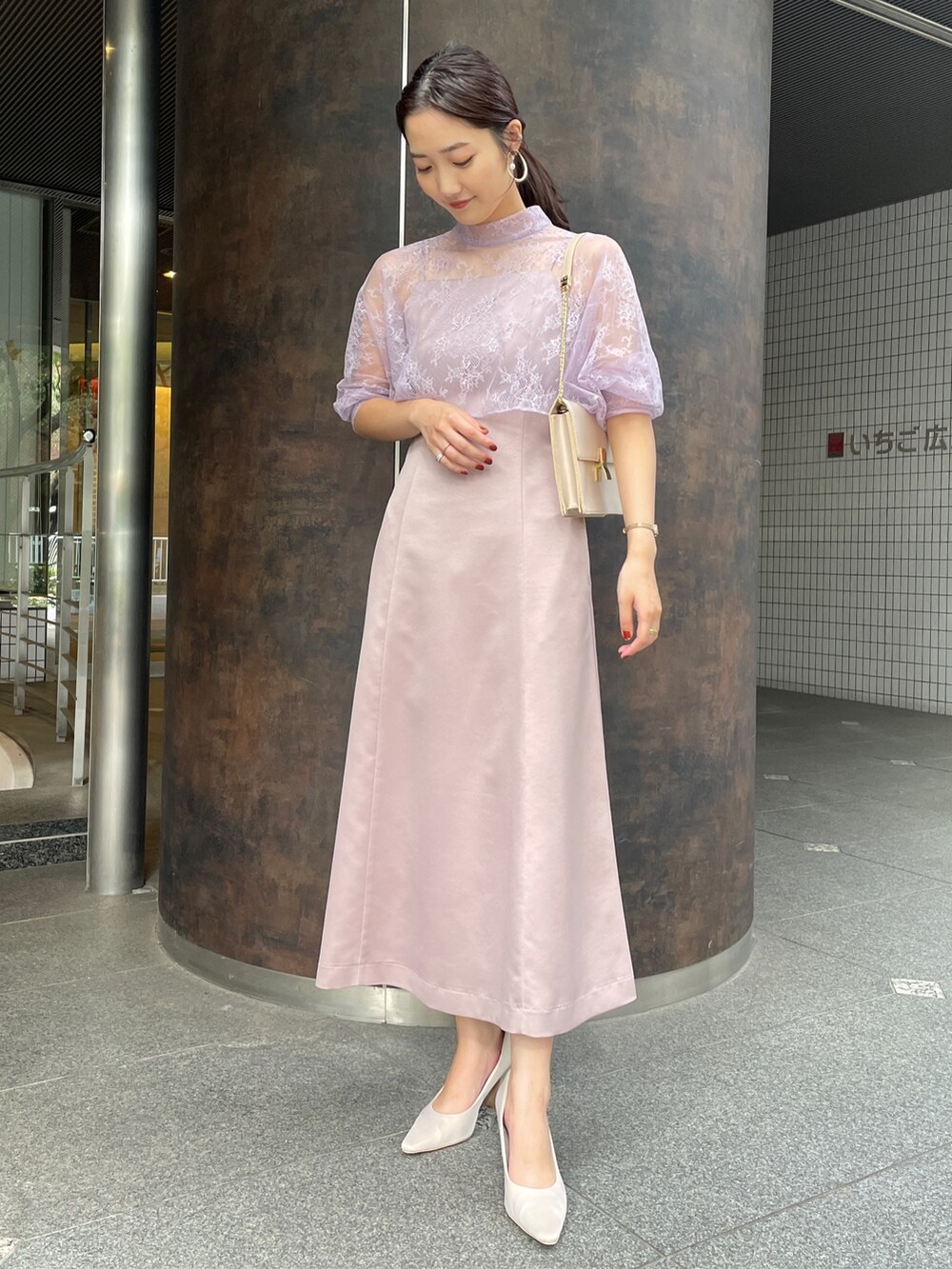 ベージュ系のパンプス、パープル系のドレス、ベージュ系のクラッチバッグを着用したレディースの冬コーディネートの3枚目の写真