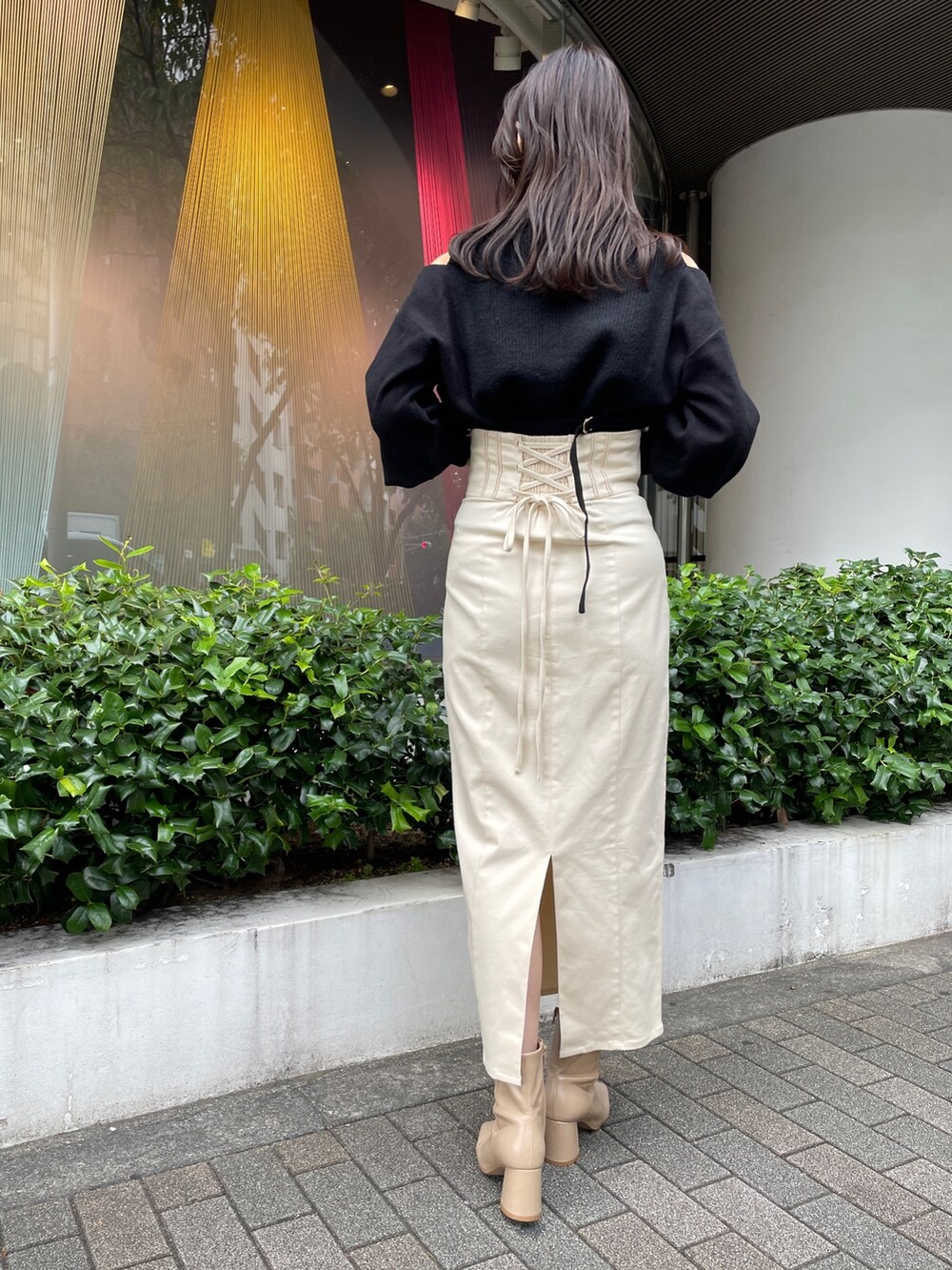 ベージュ系のブーツ、ブラック系のニット/セーター、ホワイト系のスカートを着用したレディースの秋コーディネートの5枚目の写真