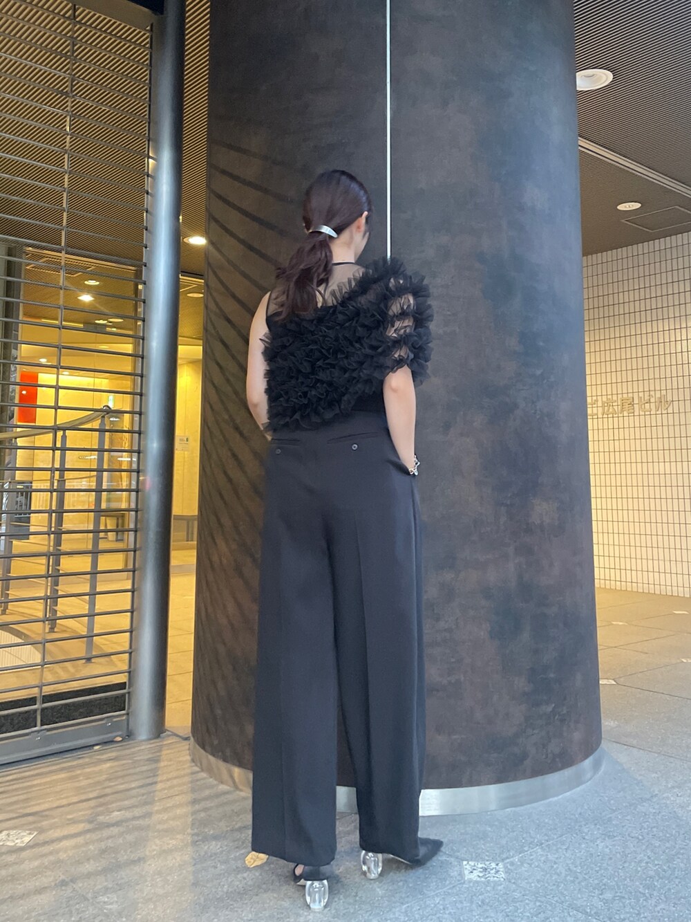 ブラック系のパンプス、ブラック系のパンツドレスを着用したレディースの秋コーディネートの3枚目の写真