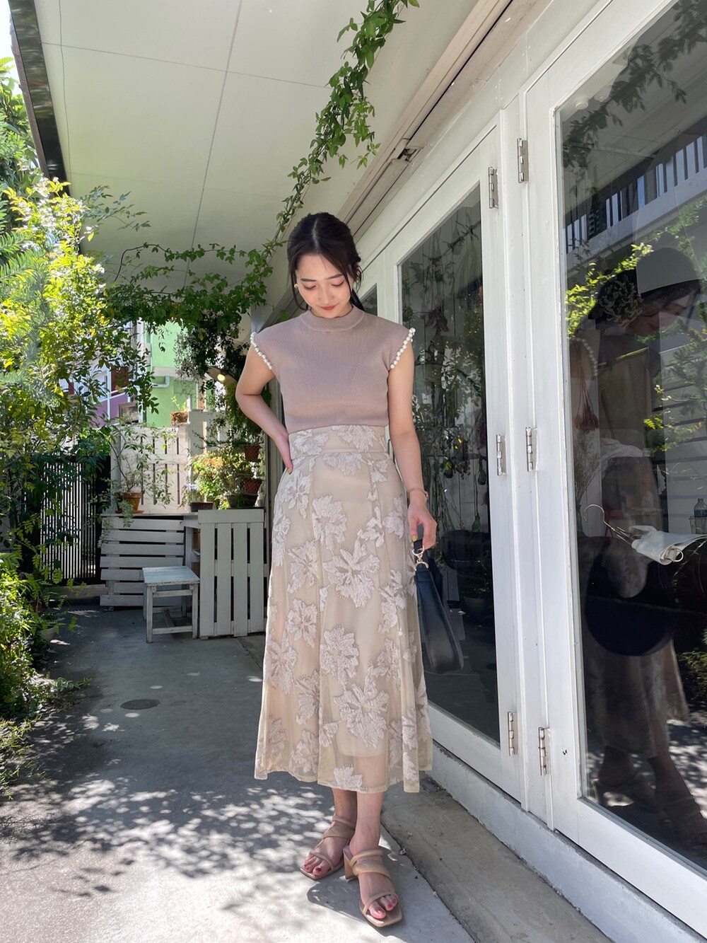 ベージュ系のサンダル、ベージュ系のニット/セーター、ベージュ系のスカートを着用したレディースの春コーディネートの5枚目の写真