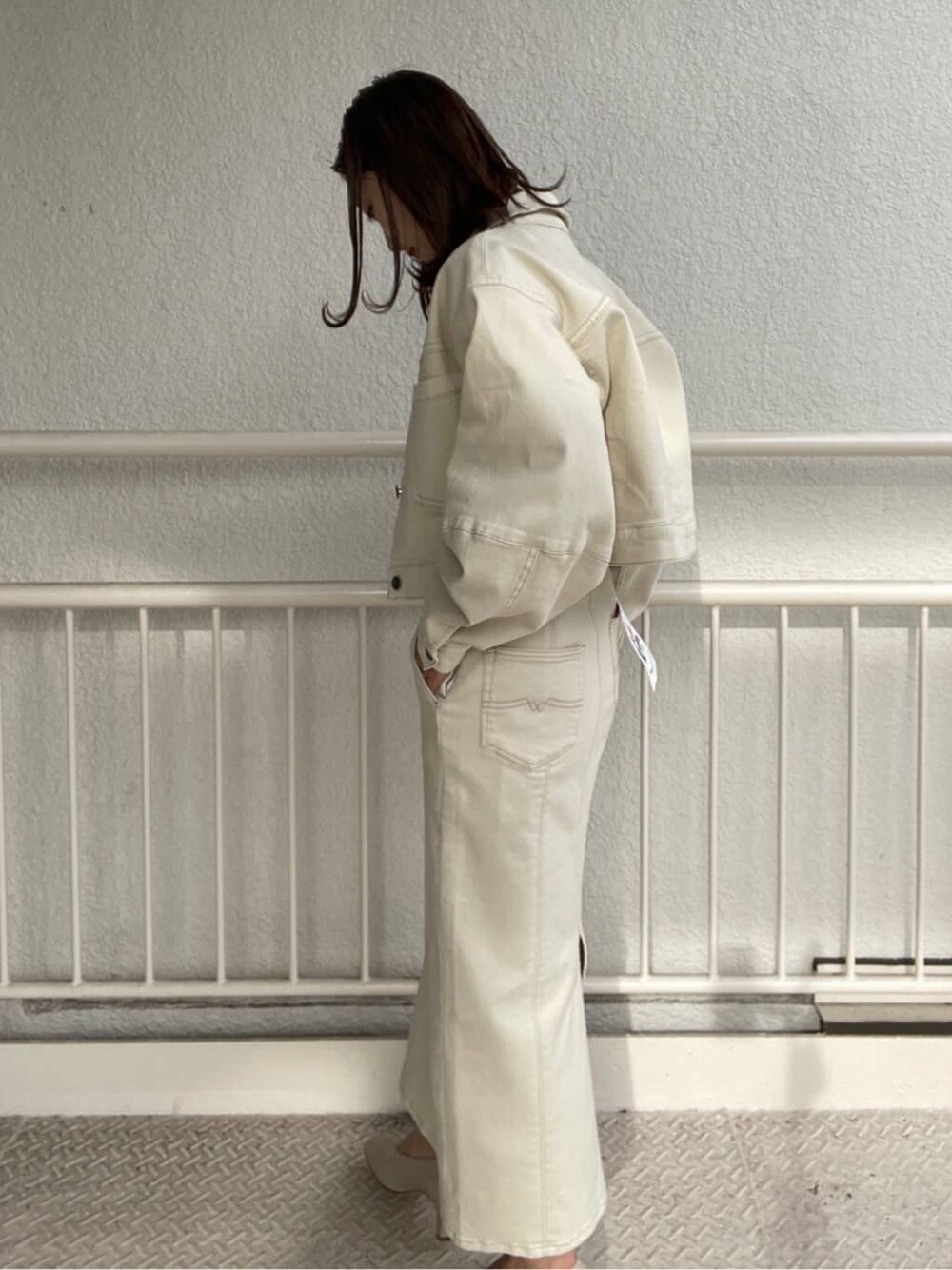 ホワイト系のブルゾン、ホワイト系のスカート、ホワイト系のパンプスを着用したレディースの冬コーディネートの6枚目の写真