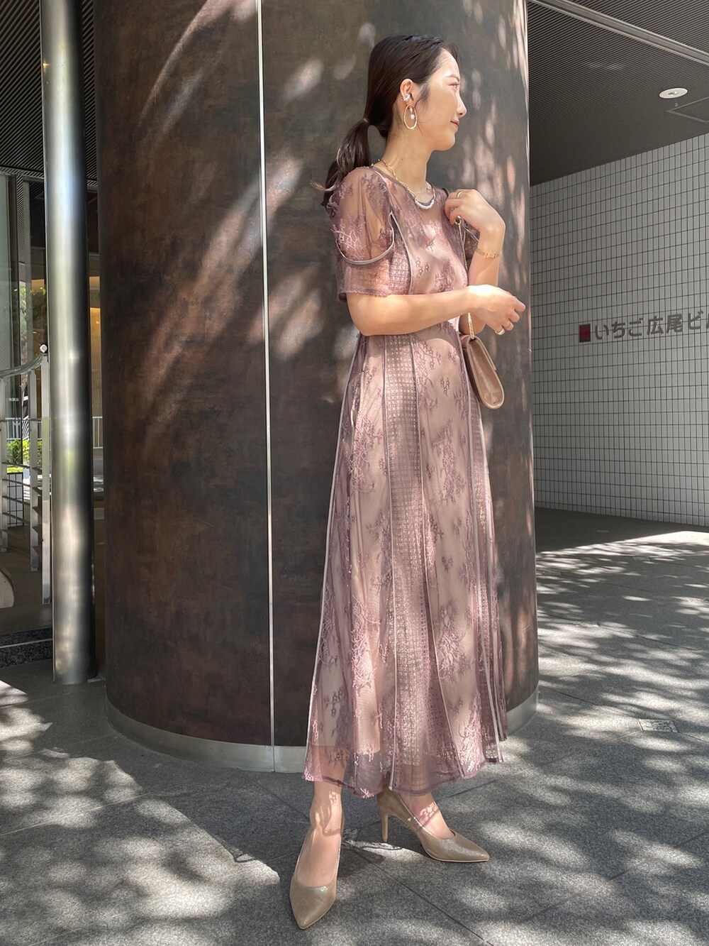 ベージュ系のドレス、ブラック系のノーカラーコート、ゴールド系のハンドバッグを着用したレディースの秋コーディネートの8枚目の写真
