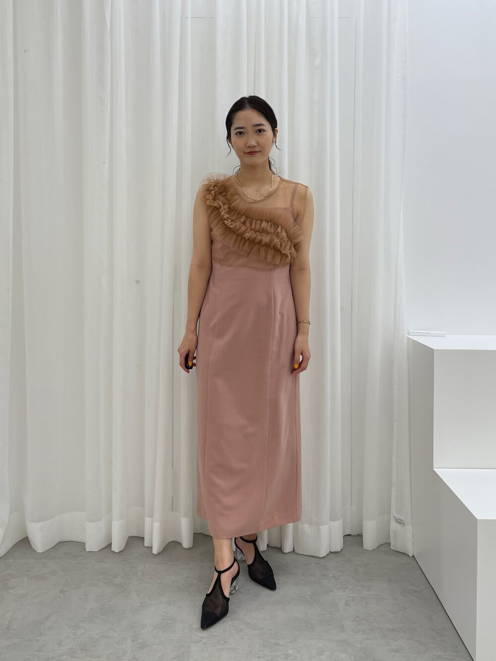 ブラック系のパンプス、ピンク系のドレスを着用したレディースの春コーディネートの3枚目の写真