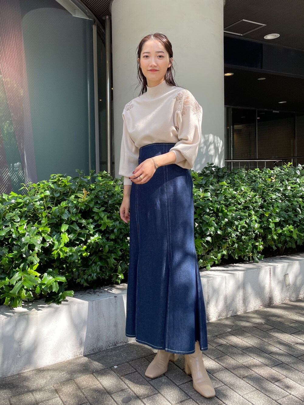 ベージュ系のブーツ、ブルー系のスカート、ホワイト系のニット/セーターを着用したレディースの秋コーディネートの5枚目の写真