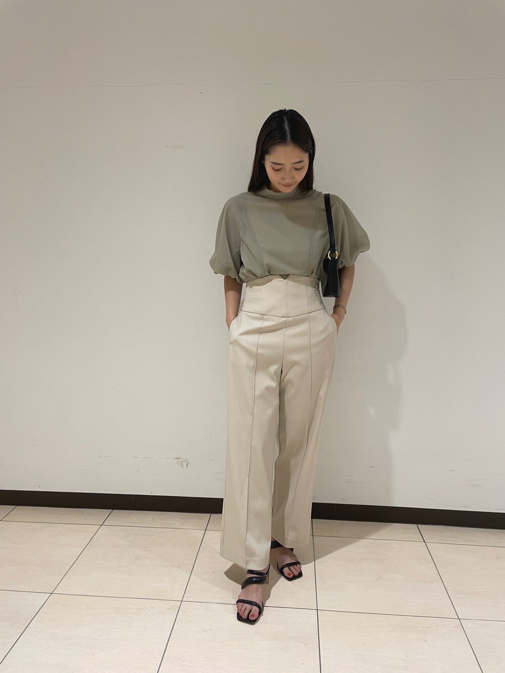 ホワイト系のその他パンツ、グリーン系のシャツ/ブラウス、ブラック系のハンドバッグを着用したレディースの春コーディネートの3枚目の写真