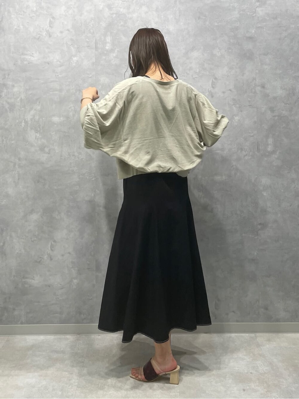 ブラウン系のサンダル、グリーン系のカーディガン/ボレロ、ブラック系のワンピースを着用したレディースの夏コーディネートの3枚目の写真