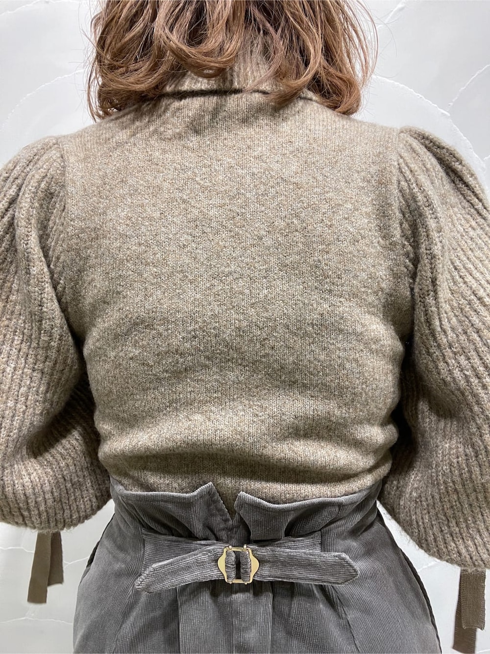 グレー系のスカート、ベージュ系のニット/セーターを着用したレディースの冬コーディネートの5枚目の写真