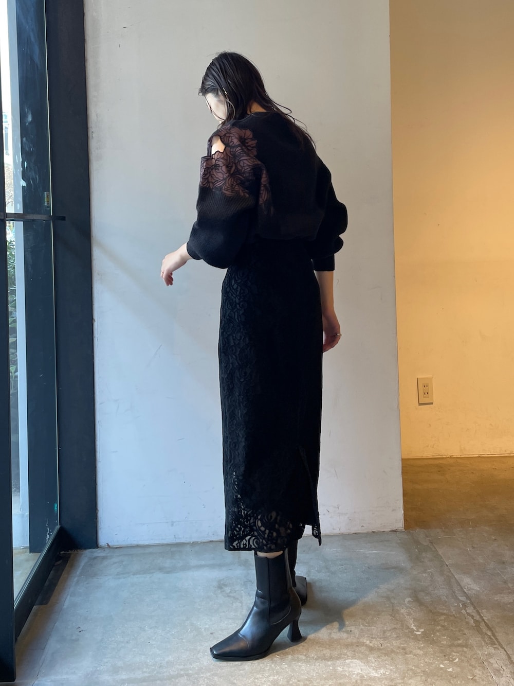 ブラック系のブーツ、ブラック系のスカート、ブラック系のニット/セーターを着用したレディースの冬コーディネートの6枚目の写真