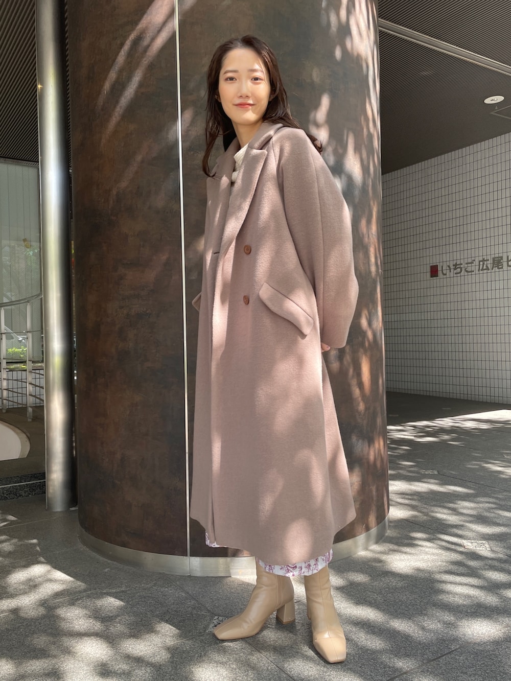 ホワイト系のニット/セーター、ベージュ系のブーツ、ピンク系のスカートを着用したレディースの秋コーディネートの2枚目の写真