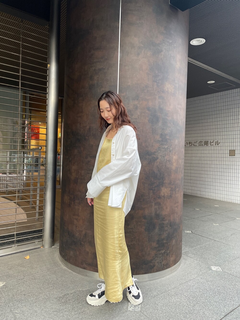 ブラック系のスニーカー、ホワイト系のシャツ/ブラウス、イエロー系のワンピースを着用したレディースの冬コーディネートの4枚目の写真