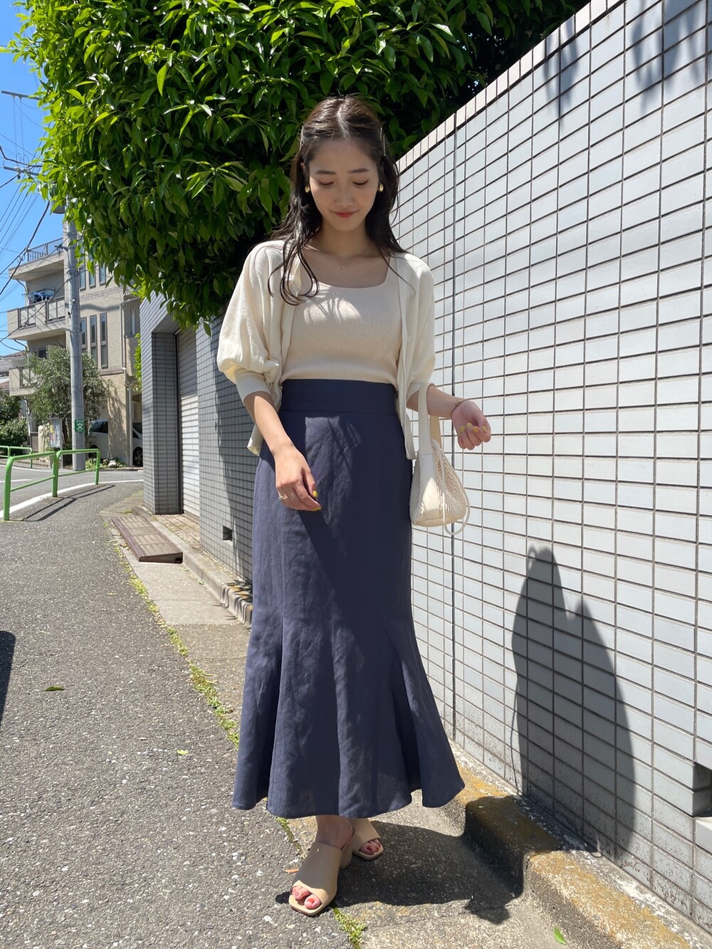 ブルー系のスカート、ホワイト系のカーディガン/ボレロ、ホワイト系のニット/セーターを着用したレディースの春コーディネートの3枚目の写真