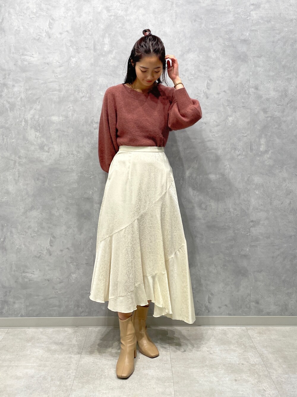 ベージュ系のブーツ、ホワイト系のスカート、ピンク系のニット/セーターを着用したレディースの冬コーディネートの2枚目の写真