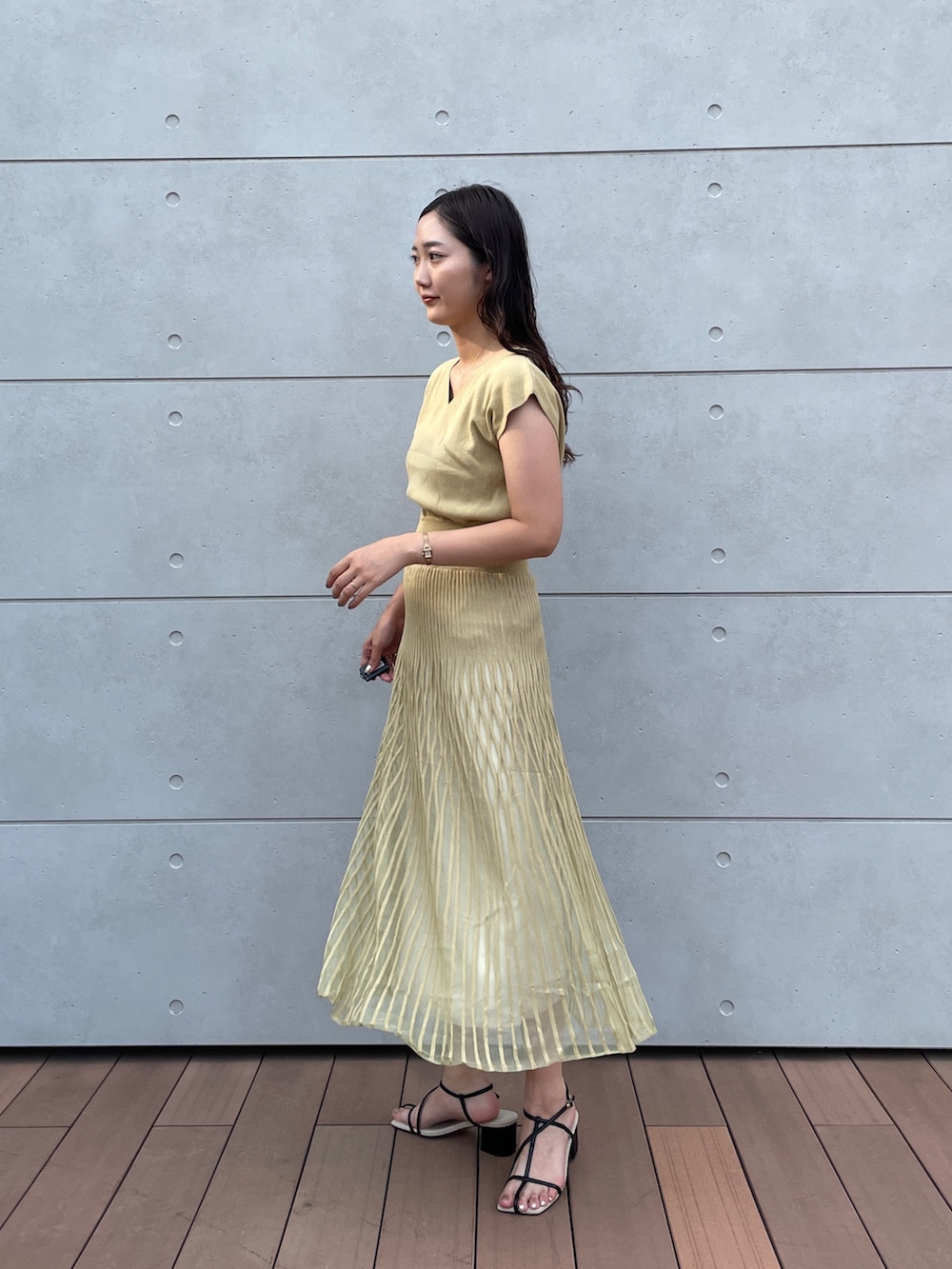 グリーン系のワンピース、ブラック系のサンダルを着用したレディースの夏コーディネートの5枚目の写真