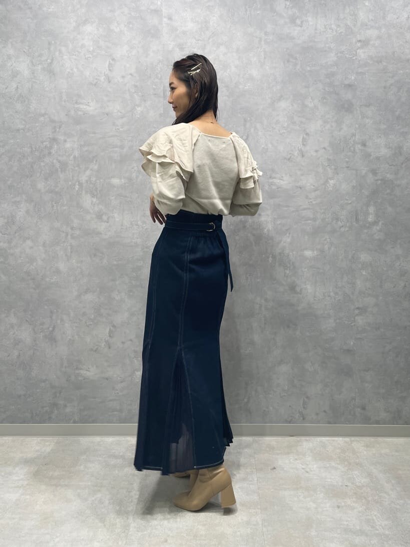 ベージュ系のブーツ、ブルー系のスカート、ホワイト系のニット/セーターを着用したレディースの秋コーディネートの6枚目の写真