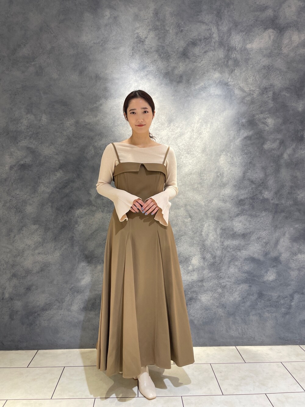 ホワイト系のニット/セーター、ベージュ系のワンピース、ホワイト系のブーツを着用したレディースの冬コーディネートの5枚目の写真