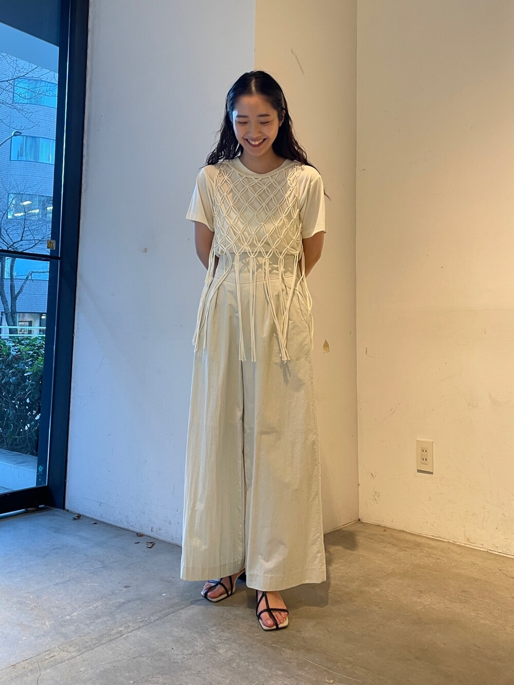 ホワイト系のその他パンツ、ブラック系のサンダル、ホワイト系のTシャツ/カットソーを着用したレディースの春コーディネートの2枚目の写真