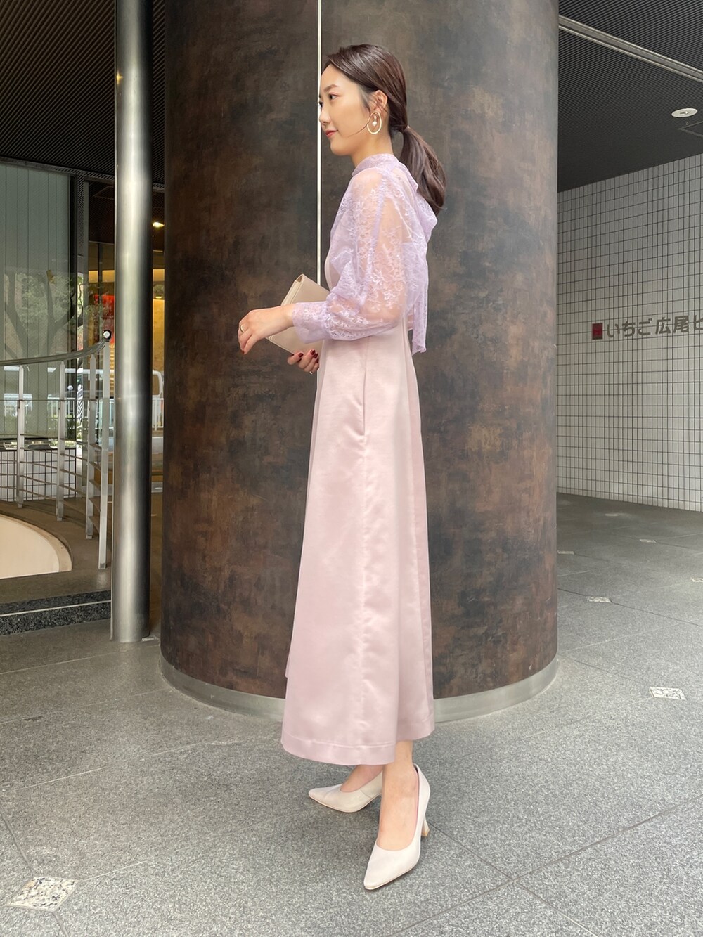 ベージュ系のパンプス、パープル系のドレス、ベージュ系のクラッチバッグを着用したレディースの冬コーディネートの7枚目の写真