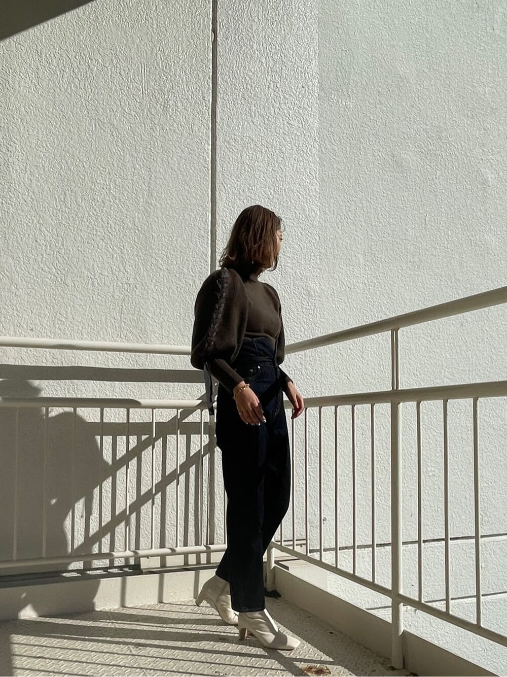 ホワイト系のその他シューズ、ブラウン系のニット/セーター、ブルー系のデニムパンツを着用したレディースの冬コーディネートの3枚目の写真