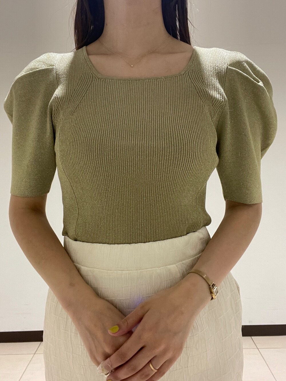 ホワイト系のスカート、グリーン系のニット/セーター、ブラック系のサンダルを着用したレディースの春コーディネートの6枚目の写真