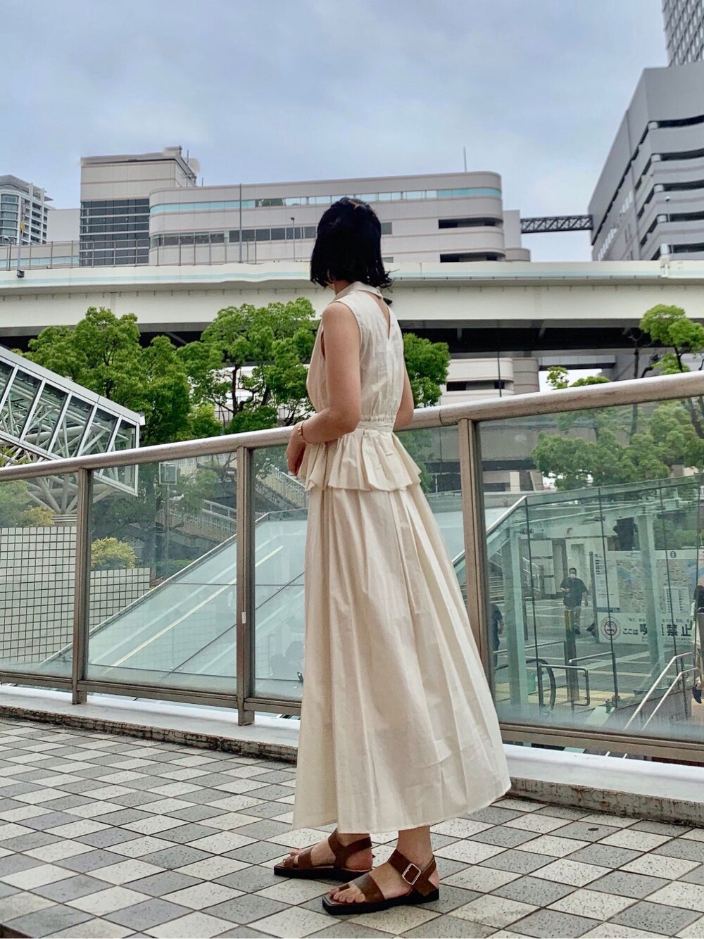 ブラウン系のサンダル、ホワイト系のワンピースを着用したレディースの夏コーディネートの6枚目の写真