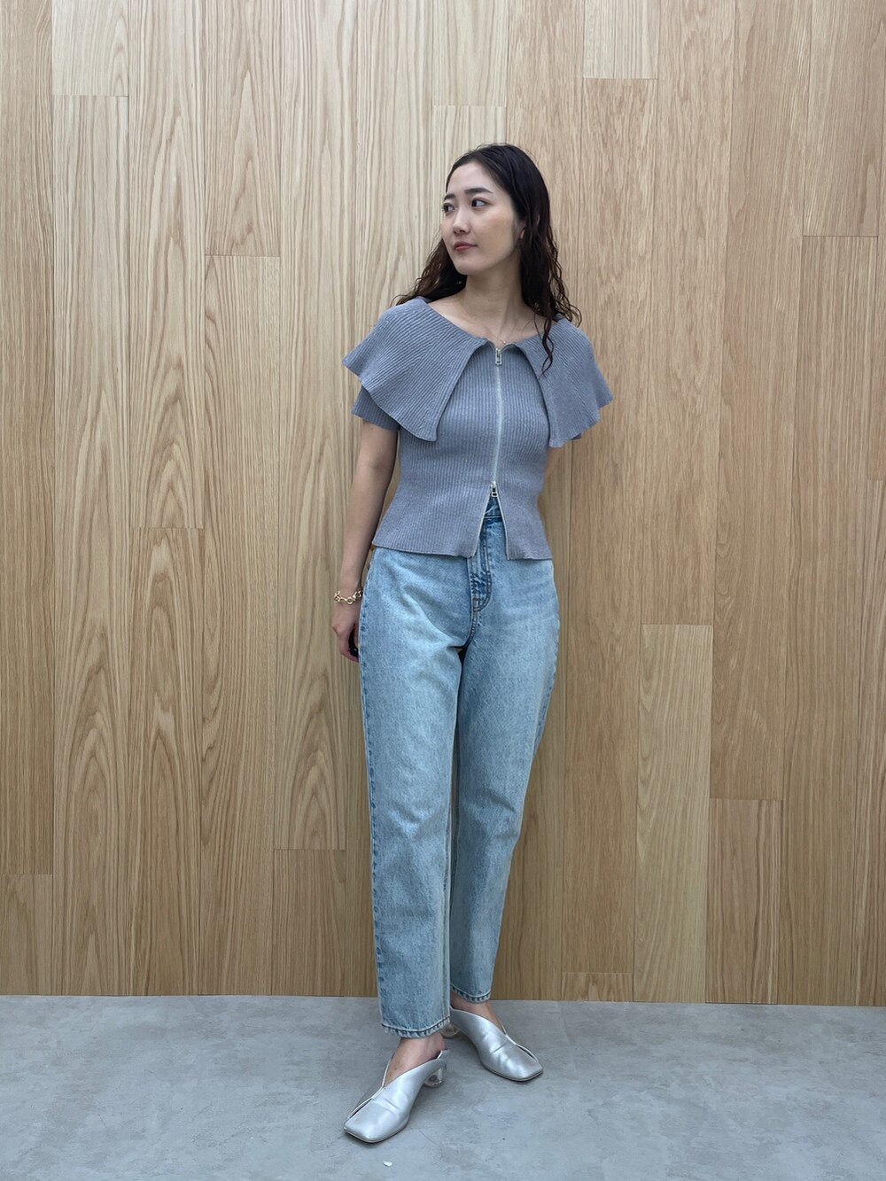 ブルー系のデニムパンツ、グレー系のニット/セーター、シルバー系のパンプスを着用したレディースの春コーディネートの5枚目の写真