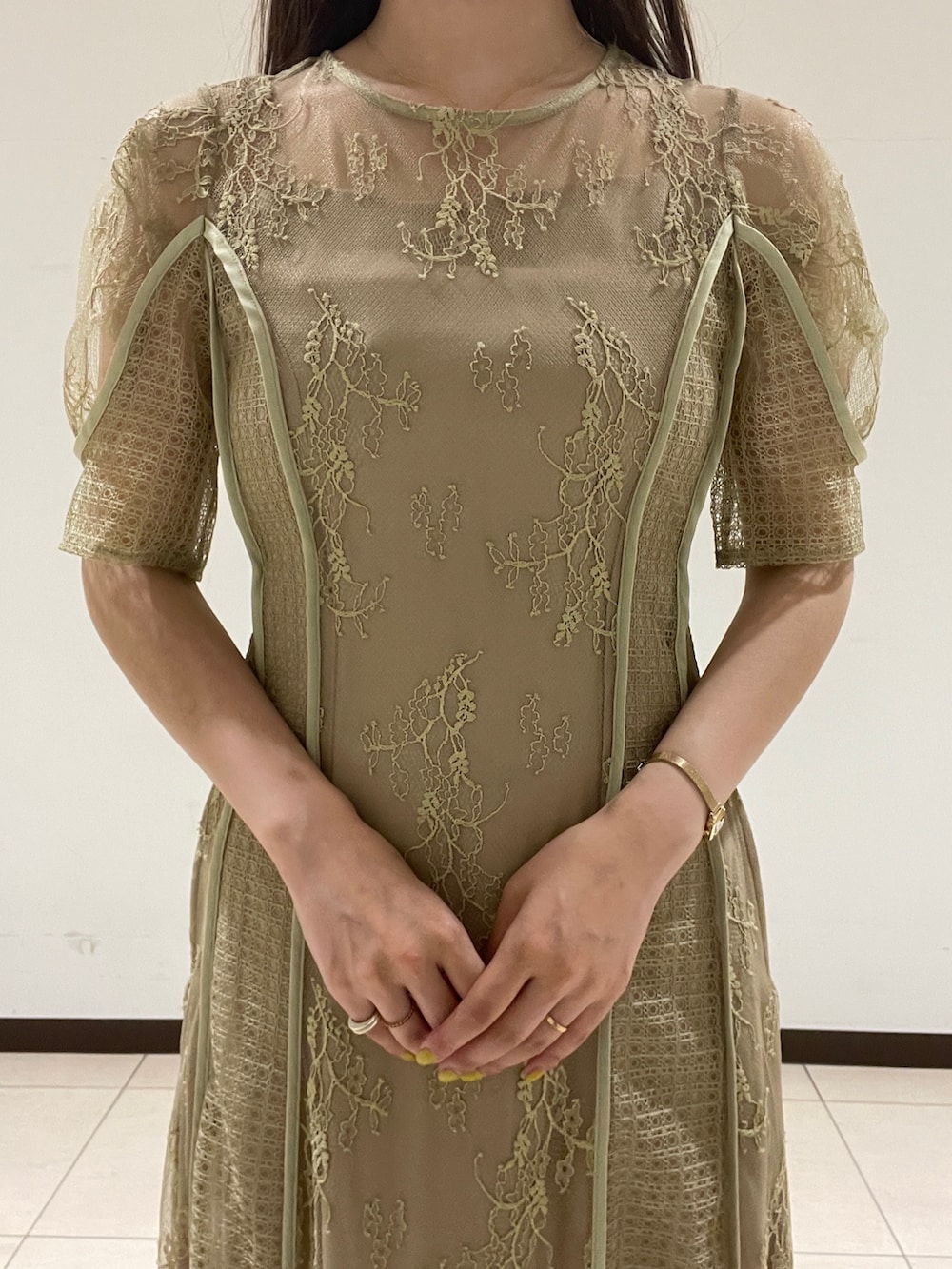 ベージュ系のパンプス、グリーン系のドレスを着用したレディースの春コーディネートの6枚目の写真