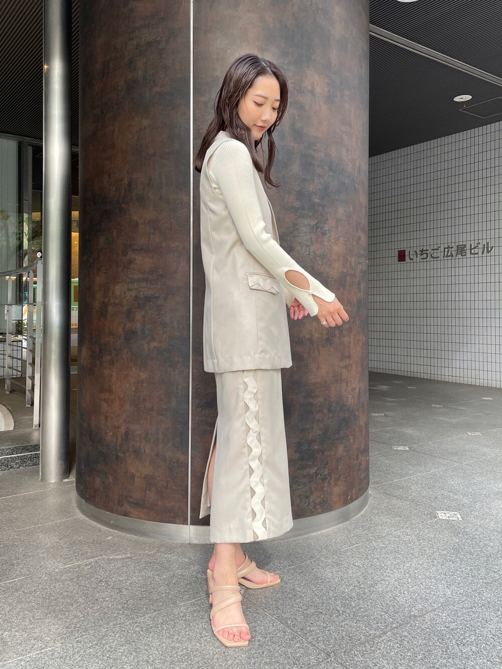 ベージュ系のサンダル、ベージュ系のスカート、ホワイト系のニット/セーターを着用したレディースの冬コーディネートの4枚目の写真