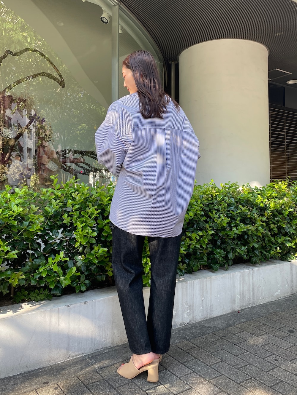 ブラック系のデニムパンツ、ベージュ系のサンダル、ブラック系のシャツ/ブラウスを着用したレディースの夏コーディネートの5枚目の写真